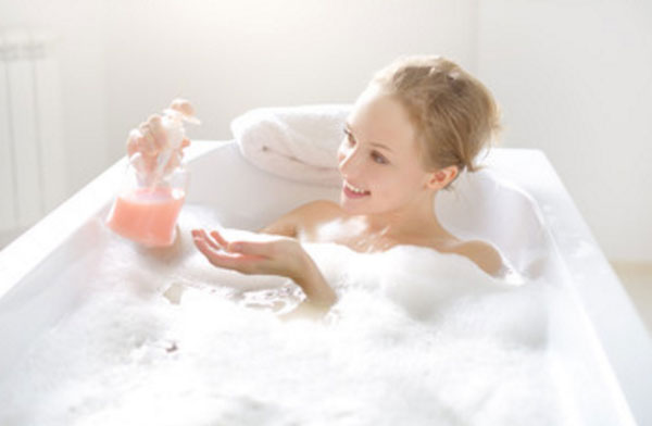 Девушка улыбается, лежит в ванне с пеной